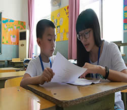 志愿者耐心地教孩子读英语发音